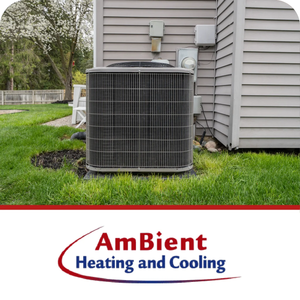 An outdoor AC unit is on a lawn next to a house, with the "AmBient Heating and Cooling" logo